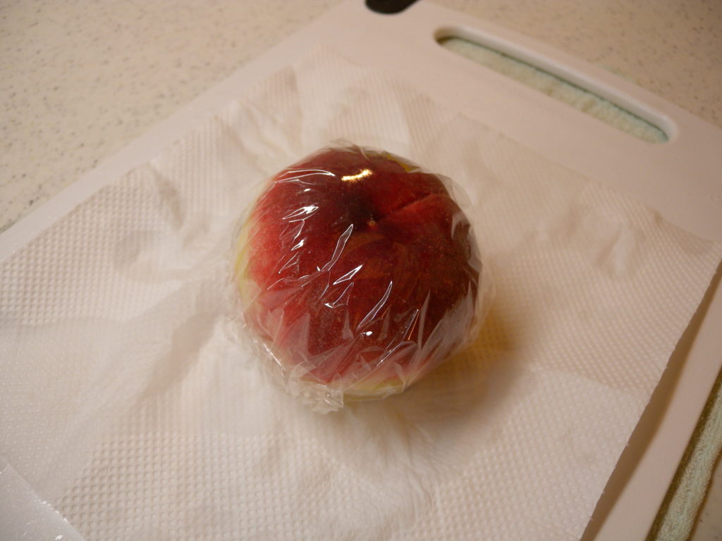 桃をラップで包んで冷凍する