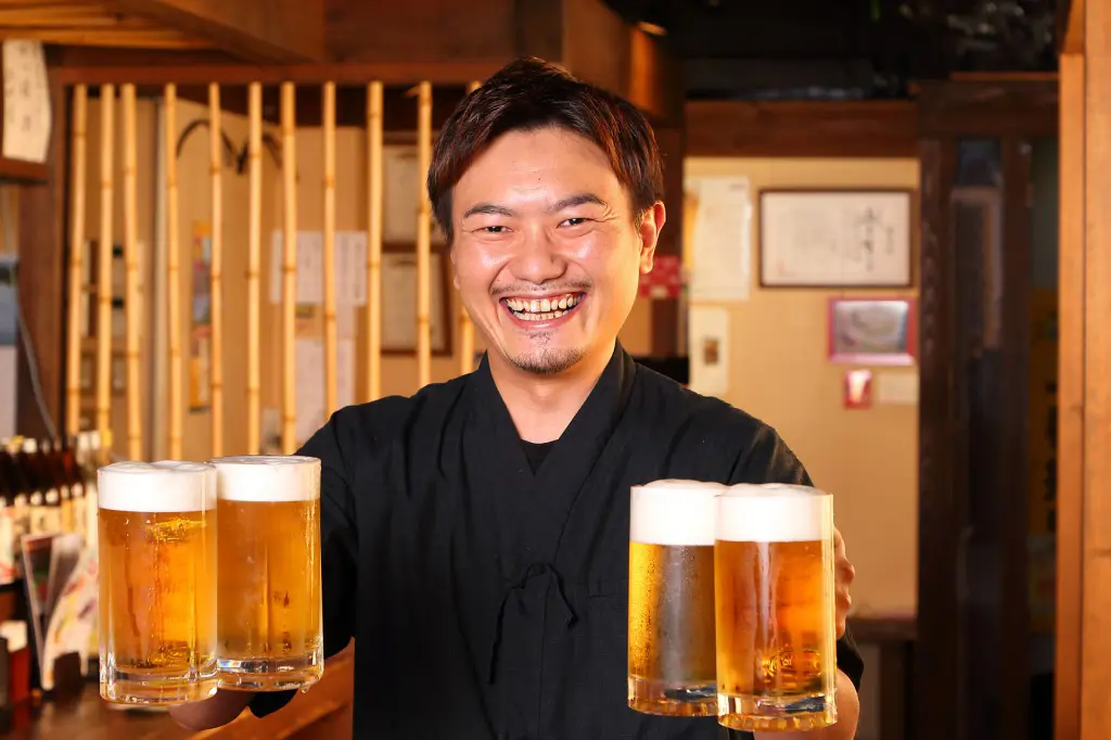 Izakaya waiter holding four beer mugs